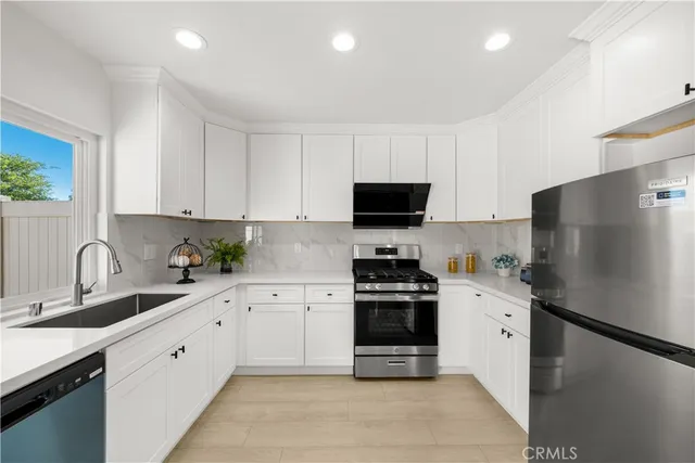 a kitchen with stainless steel appliances a stove sink microwave and refrigerator