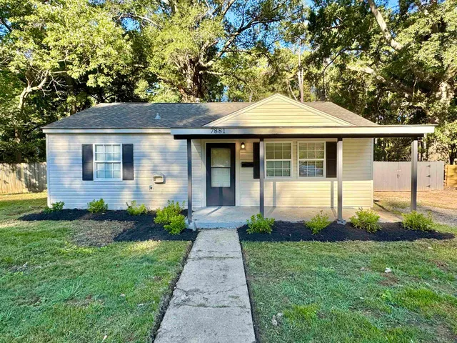 a front view of a house with a garden and plants