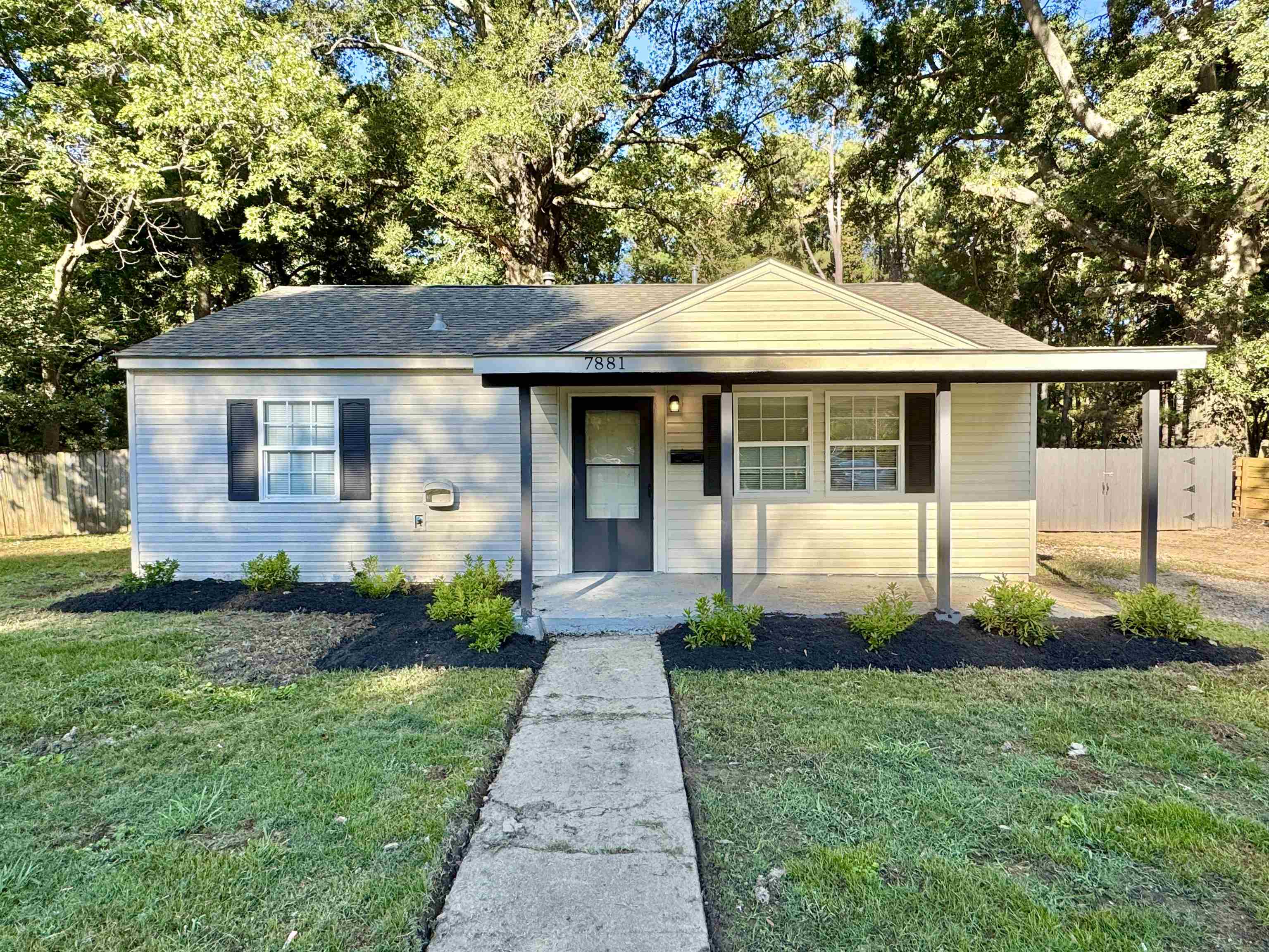 a front view of a house with a garden and plants