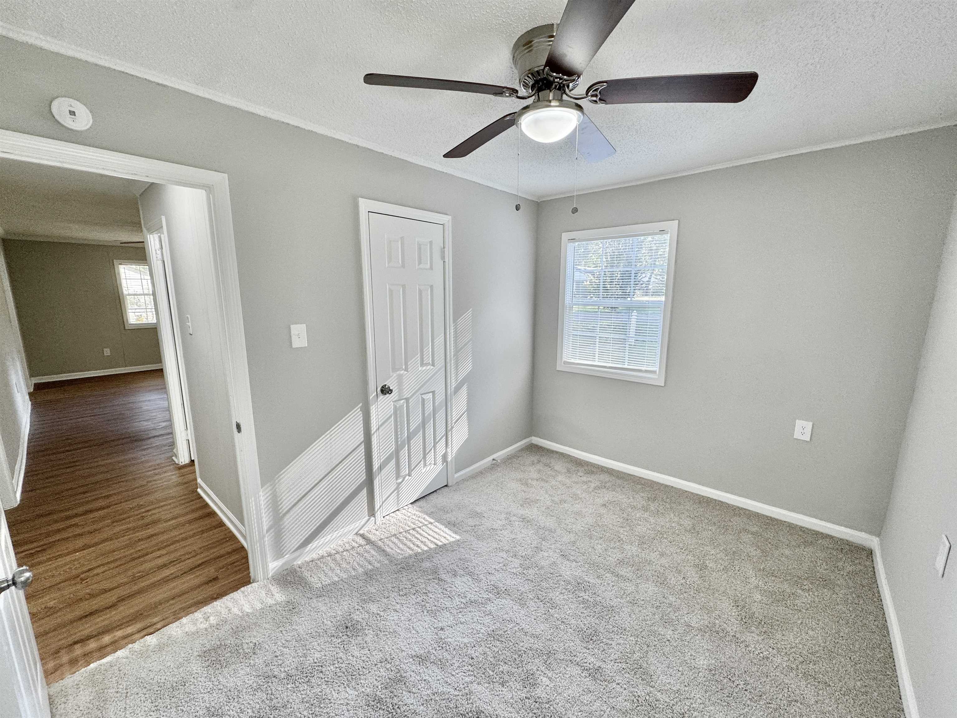 7881 Sherman Road Millington, TN 38053 - Photo 20 of 30 an empty room with wooden floor fan and windows