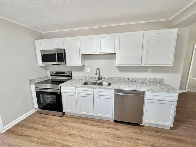 a kitchen with stainless steel appliances granite countertop a sink stove and cabinets