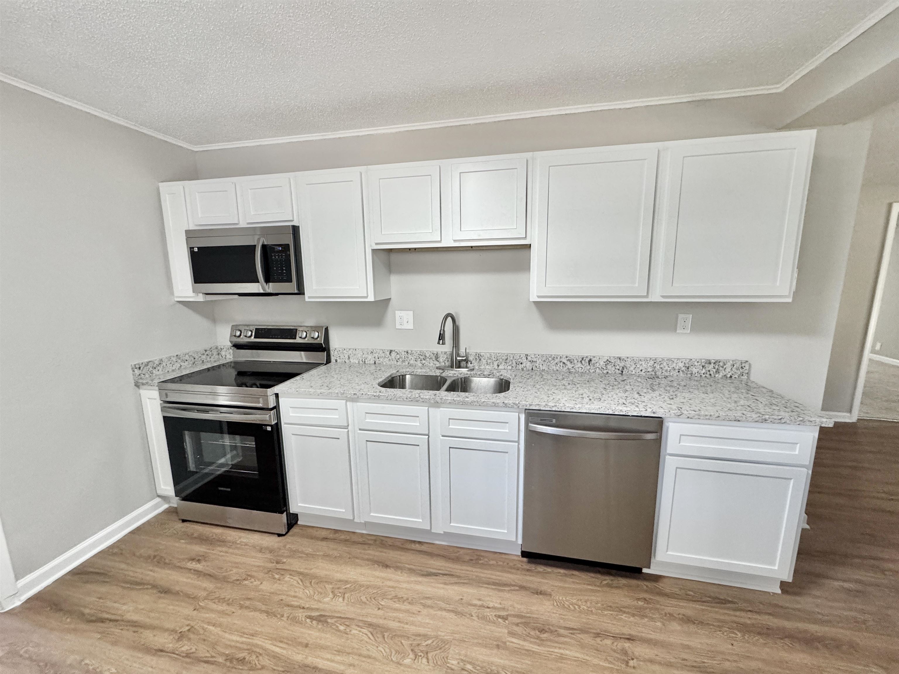 7881 Sherman Road Millington, TN 38053 - Photo 4 of 30 a kitchen with cabinets stainless steel appliances and wooden floor