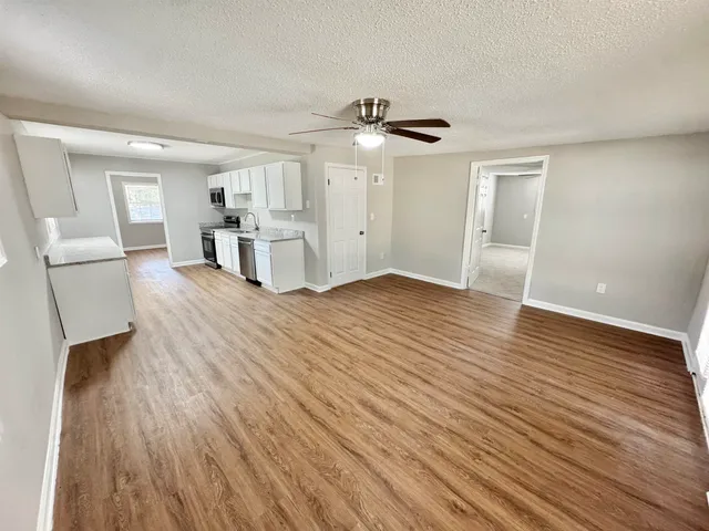 a view of empty room with wooden floor