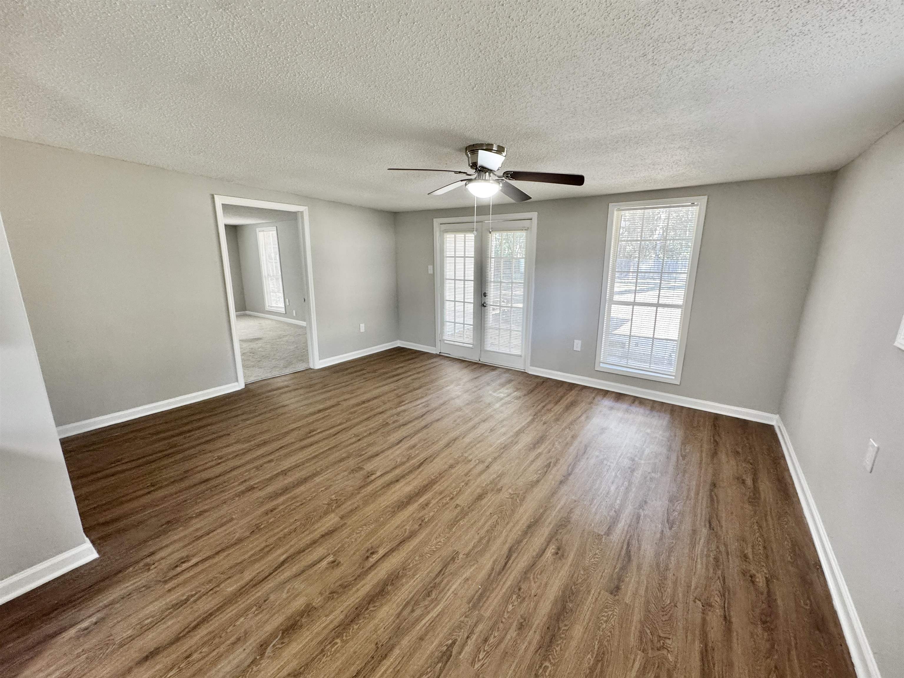7881 Sherman Road Millington, TN 38053 - Photo 9 of 30 a view of an empty room with wooden floor and a window