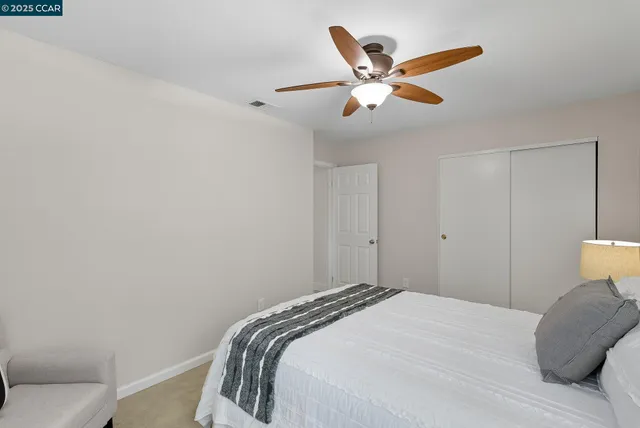a bedroom with a bed and a ceiling fan