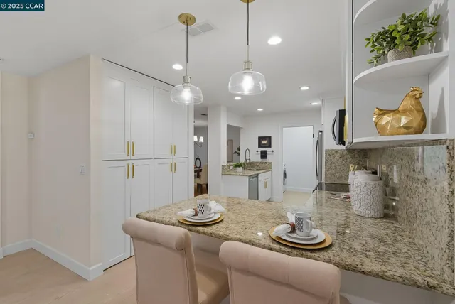 a kitchen with stainless steel appliances granite countertop a sink a stove and refrigerator