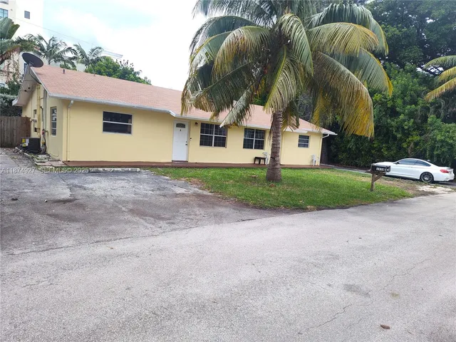 a view of a white house with a sink and yard