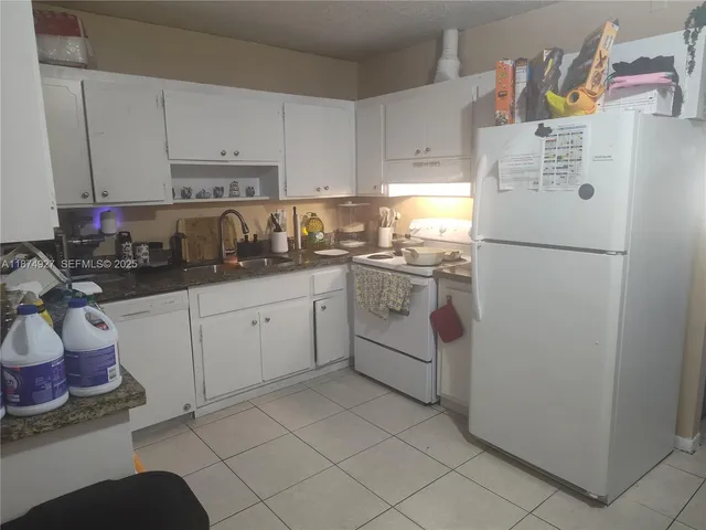 a kitchen with a refrigerator sink and cabinets
