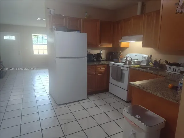 a kitchen with stainless steel appliances granite countertop a refrigerator sink and stove