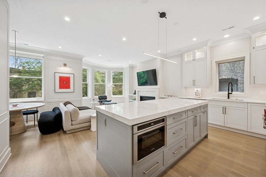 2136 North Cleveland Avenue, Unit 2 Chicago, IL 60614 - Photo 18 of 38 a open kitchen with stainless steel appliances granite countertop a stove top oven a sink dishwasher a dining table and chairs with wooden floor