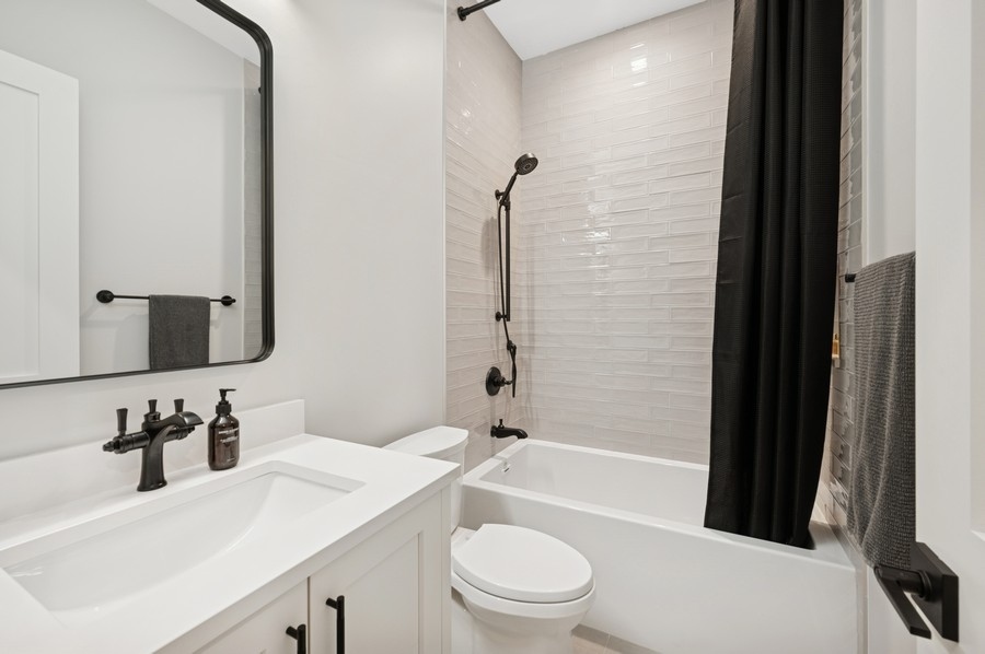 2136 North Cleveland Avenue, Unit 2 Chicago, IL 60614 - Photo 35 of 38 a bathroom with a bathtub shower sink vanity mirror and toilet