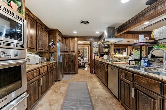 a large kitchen with stainless steel appliances granite countertop lots of counter top space