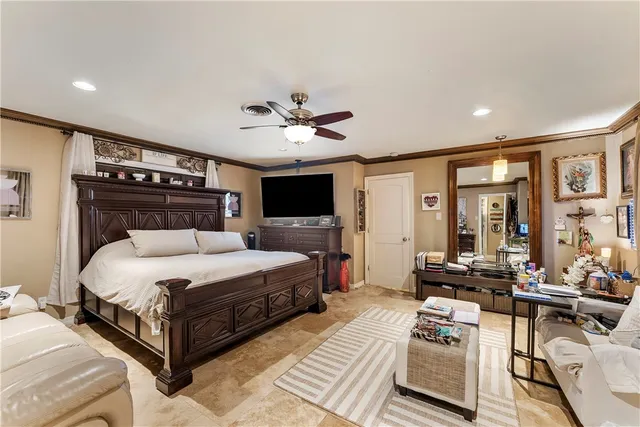 a bed room with a bed couches and a flat tv screen