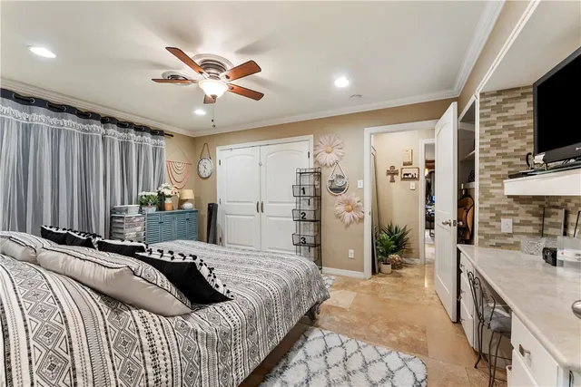 a bedroom with a bed a flat screen tv and a large window