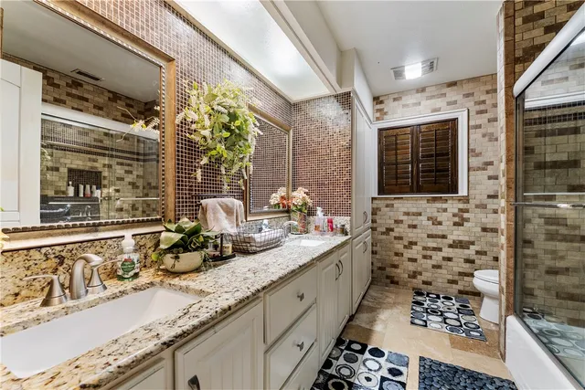 a bathroom with a granite countertop sink a large mirror and a shower