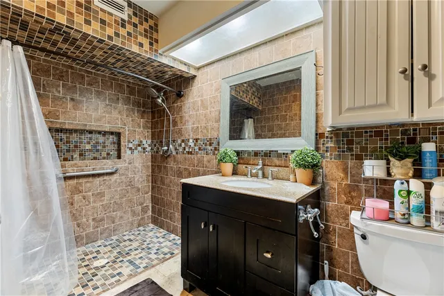 a bathroom with a sink a toilet and shower