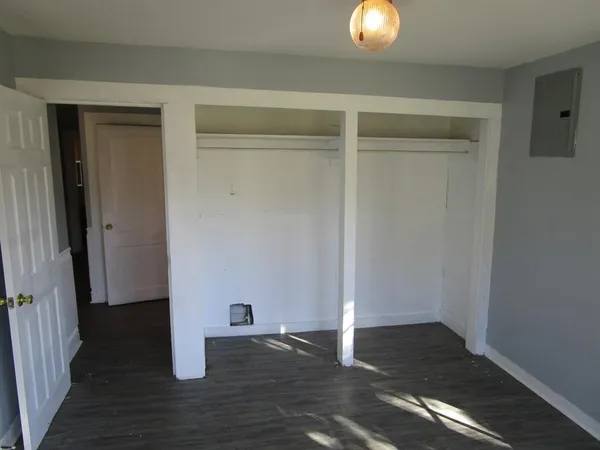 a view of an empty room with wooden floor