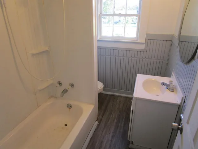 a bathroom with a tub sink and window