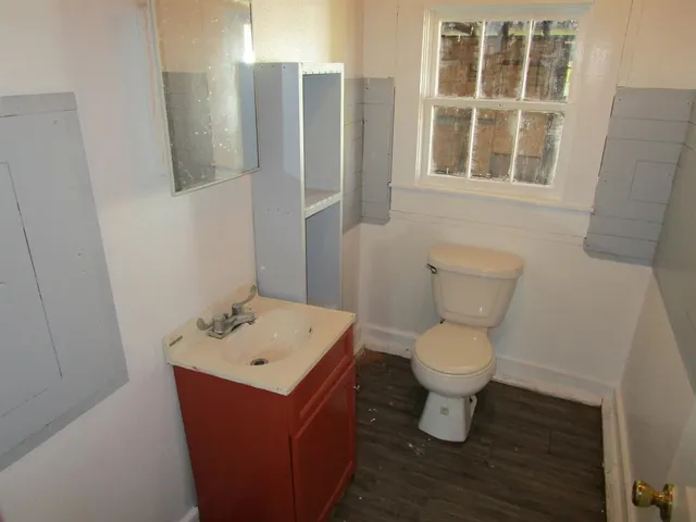 a bathroom with a toilet sink and mirror