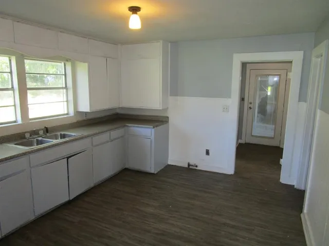a kitchen with sink cabinets and wooden floor