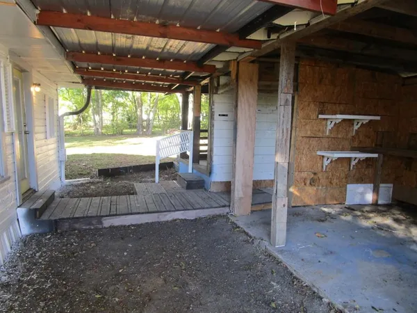 a view of a porch with a table and chairs