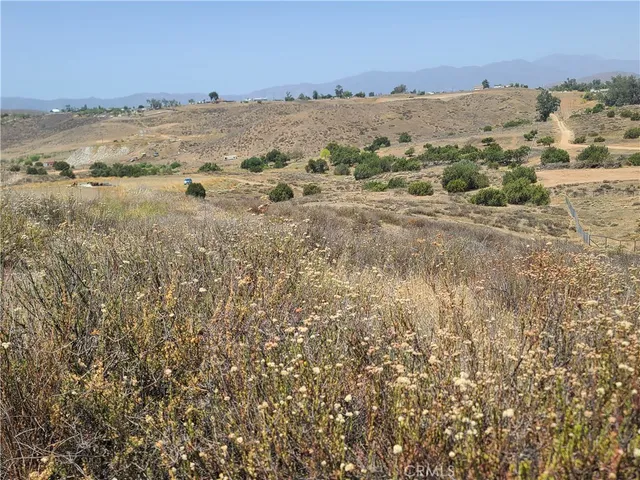 a view of a dry yard with mountains in the background