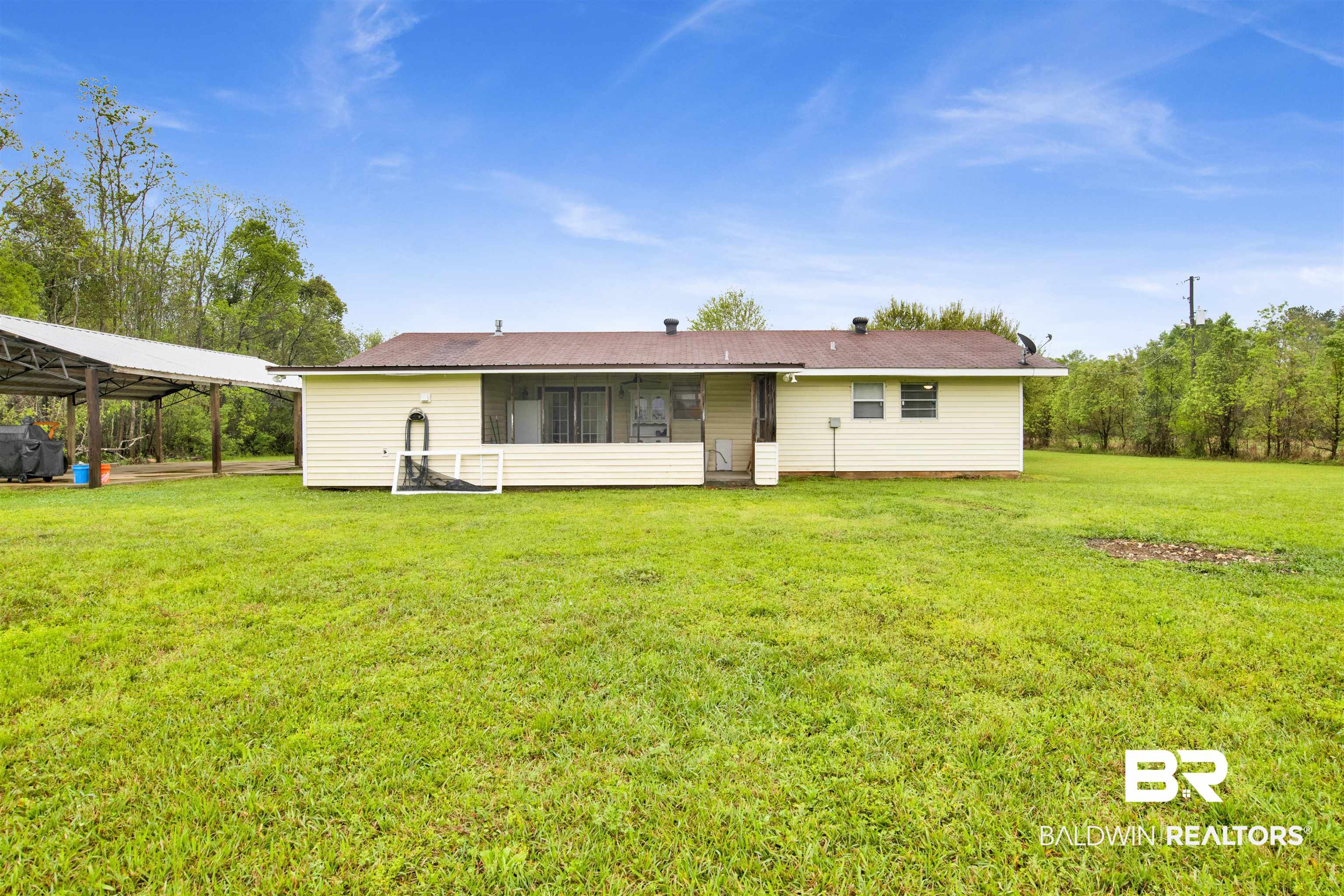 10244 Magnolia Road Irvington, AL 36544 - Photo 28 of 37 Back of house featuring a lawn and a carport