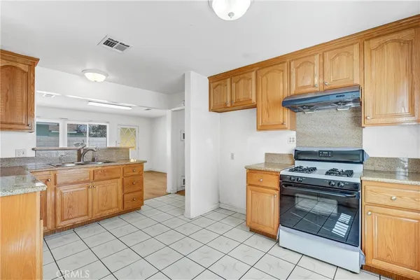 a kitchen with stainless steel appliances granite countertop a stove and a sink