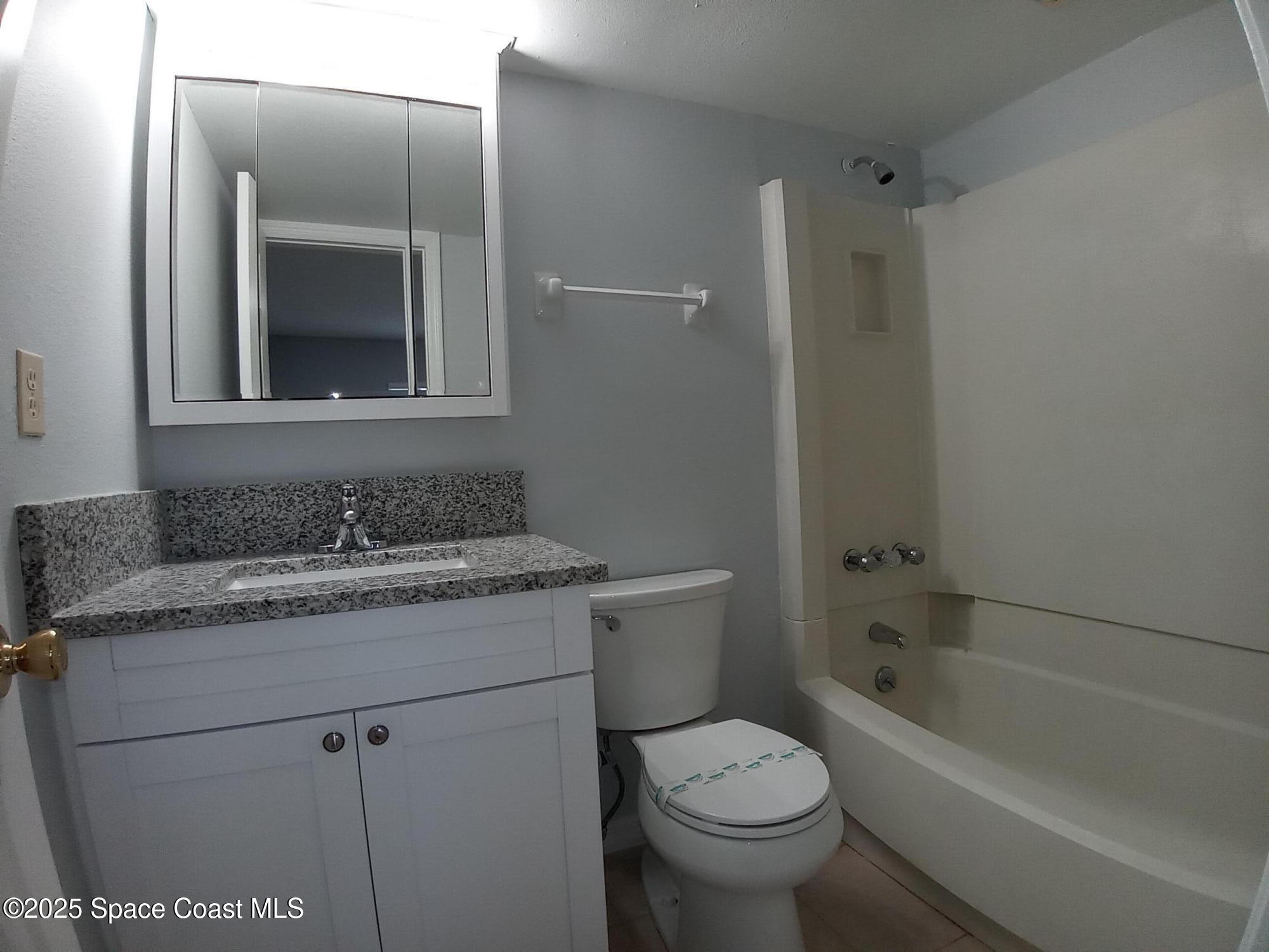 183 Ulster Lane Melbourne, FL 32935 - Photo 21 of 43 a bathroom with a granite countertop sink toilet and shower