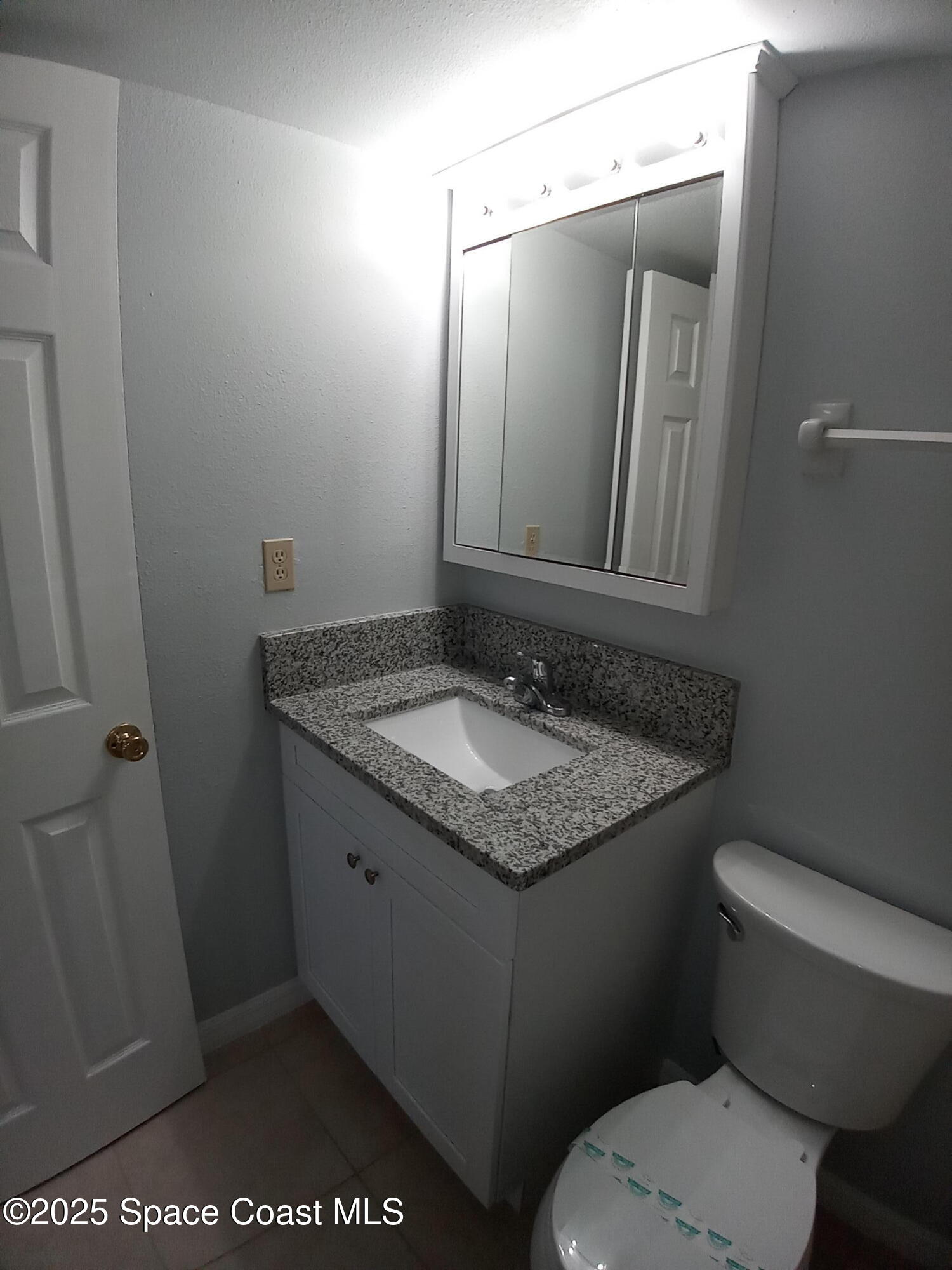 183 Ulster Lane Melbourne, FL 32935 - Photo 22 of 43 a bathroom with a granite countertop sink toilet and mirror