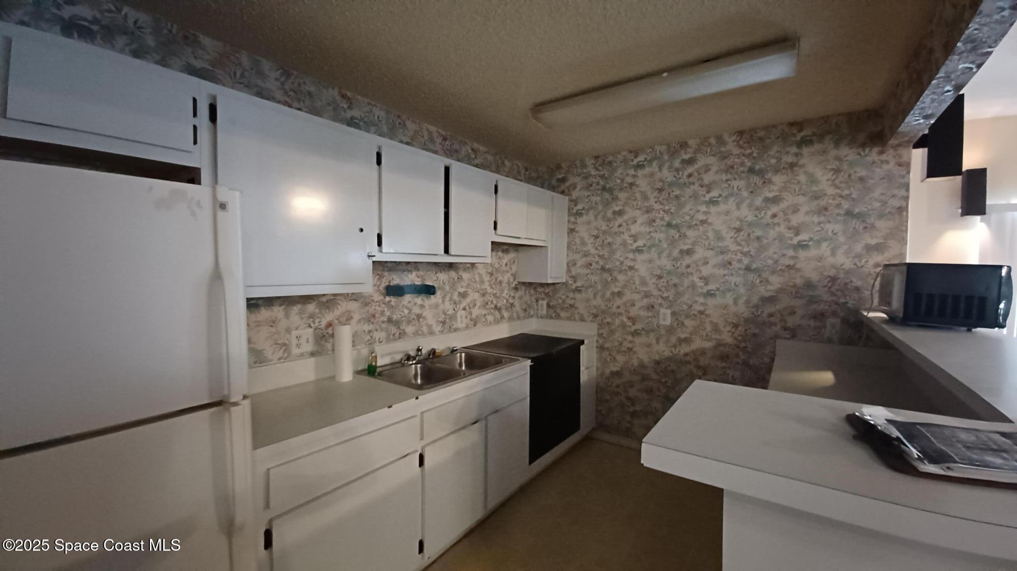 183 Ulster Lane Melbourne, FL 32935 - Photo 41 of 43 a kitchen with a sink and cabinets