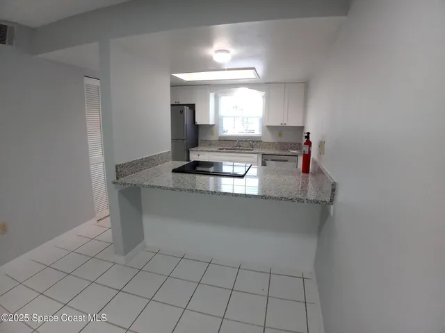 a kitchen with kitchen island a sink and a stove with white countertops