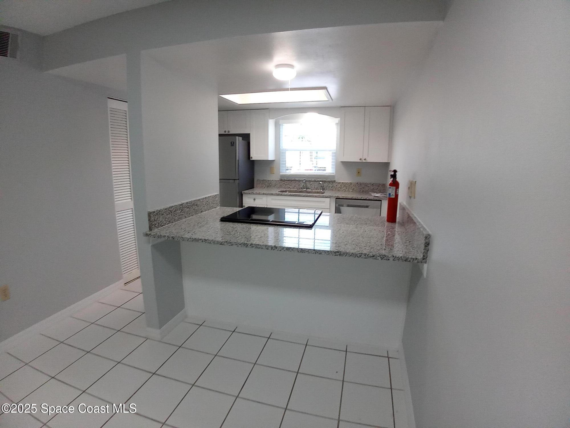 183 Ulster Lane Melbourne, FL 32935 - Photo 8 of 43 a kitchen with kitchen island a sink and a stove with white countertops