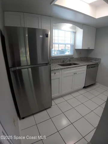 a kitchen with stainless steel appliances a refrigerator sink and cabinets