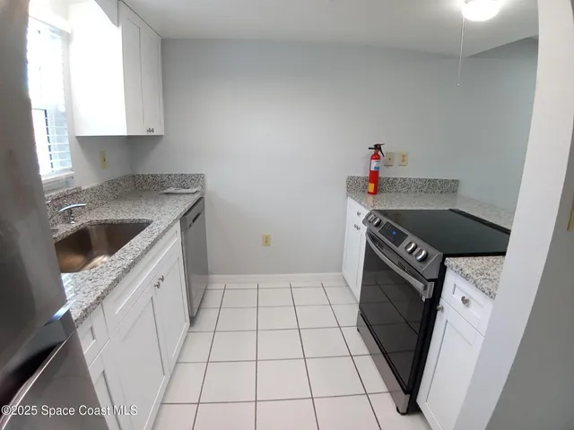a kitchen with a sink a stove and cabinets