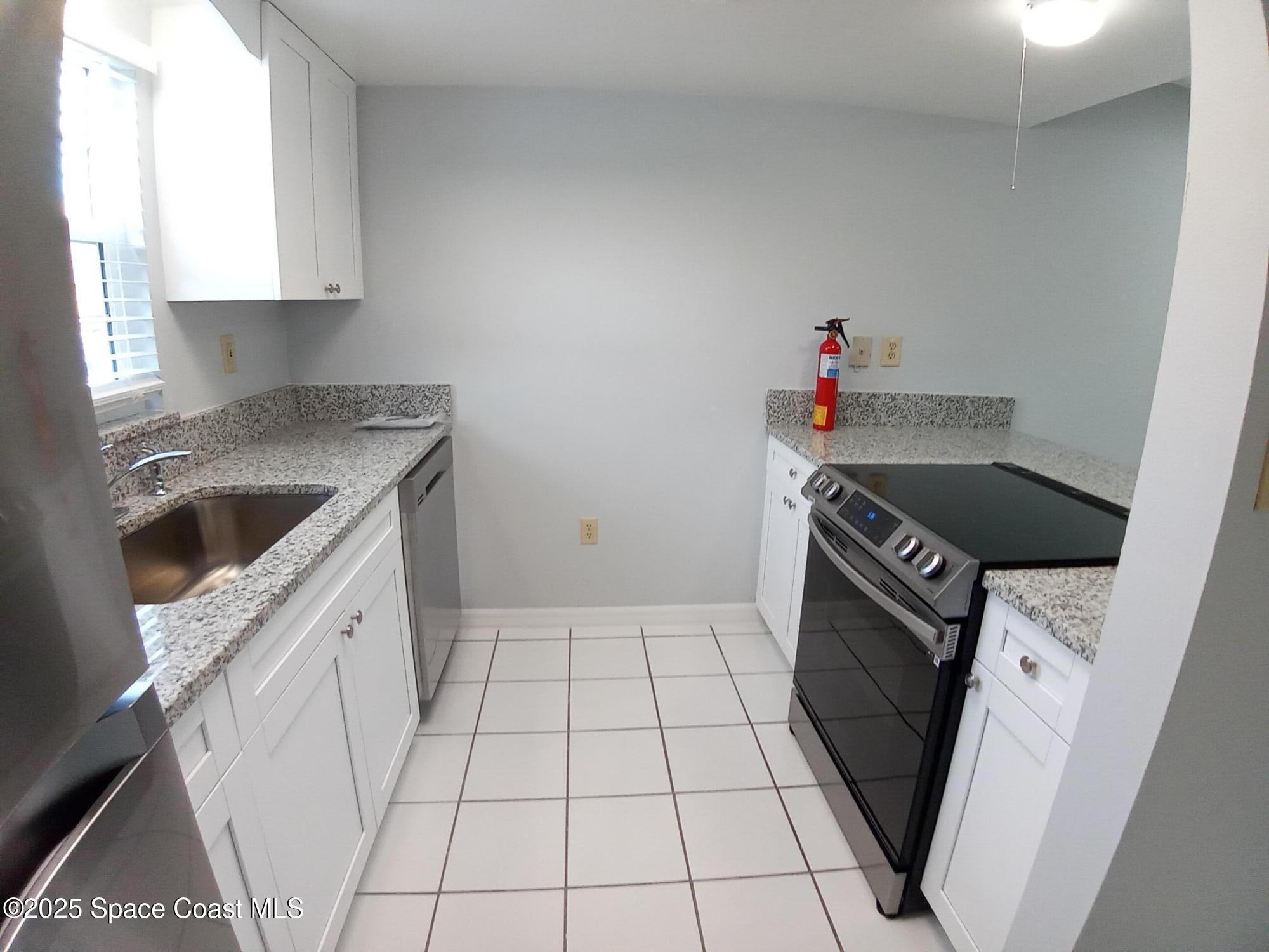 183 Ulster Lane Melbourne, FL 32935 - Photo 10 of 43 a kitchen with a sink a stove and cabinets