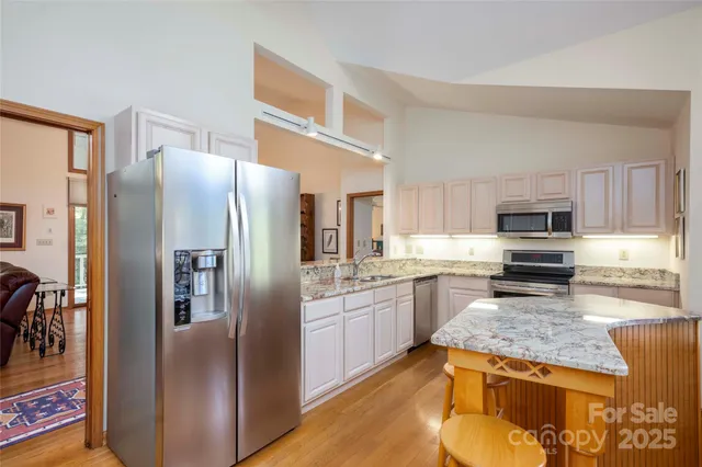 a kitchen with stainless steel appliances granite countertop a refrigerator stove and oven