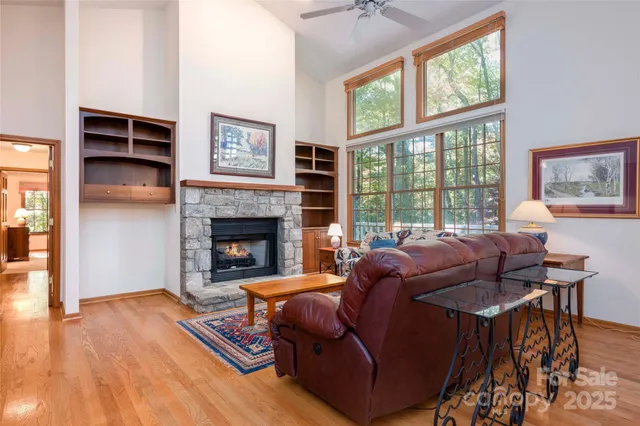 a living room with furniture a large window and a fireplace