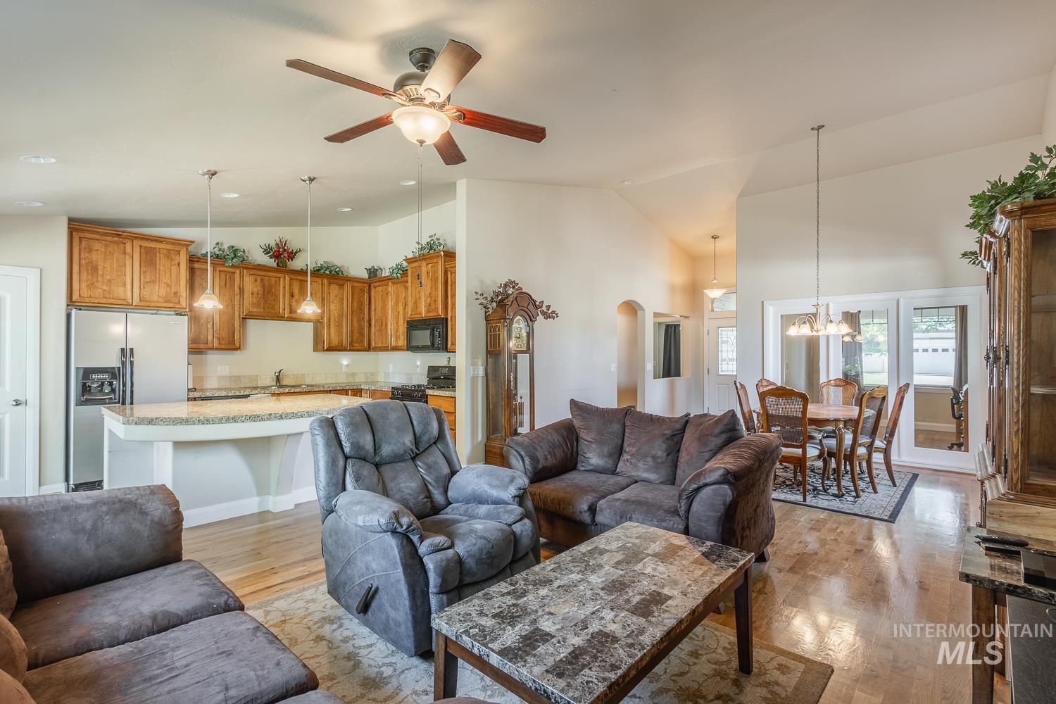 1186 East Observation Street Meridian, ID 83642 - Photo 10 of 33 Open-concept living space featuring wood-finish flooring, vaulted ceilings, and a ceiling fan