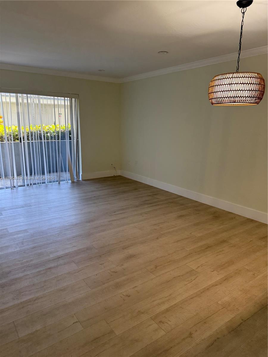7403 Southwest 82nd Street, Unit 109N Miami, FL 33143 - Photo 3 of 16 an empty room with wooden floor and windows