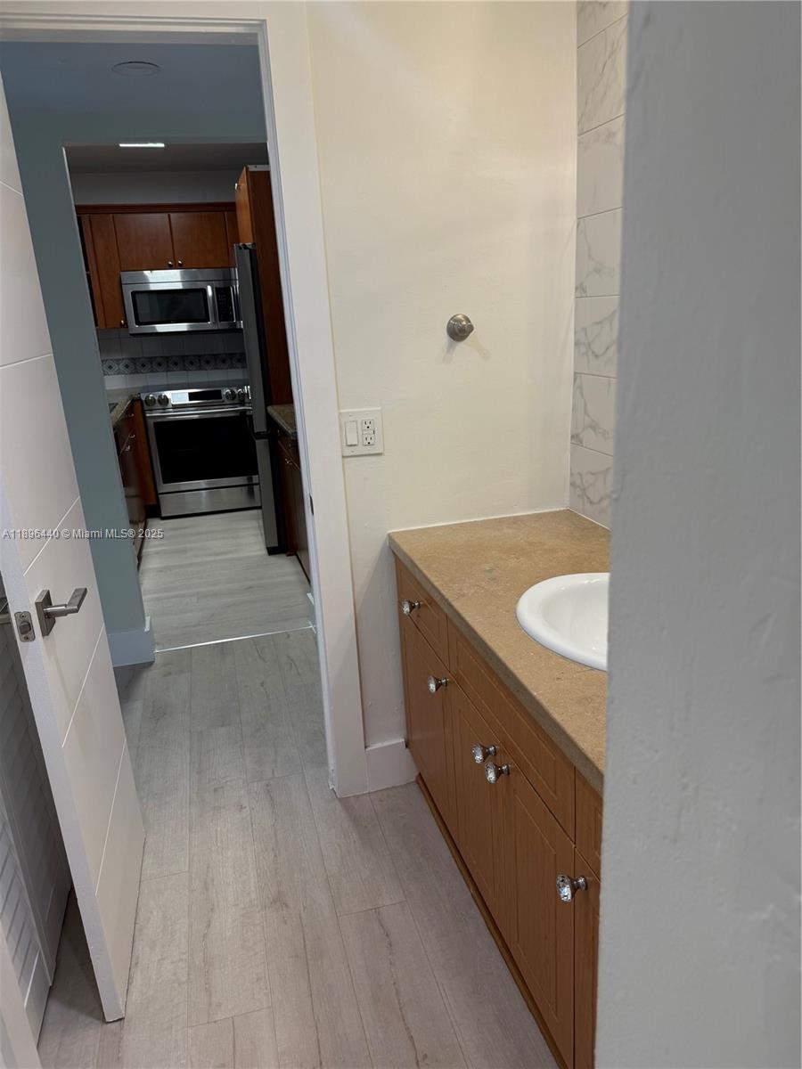 7403 Southwest 82nd Street, Unit 109N Miami, FL 33143 - Photo 10 of 16 a bathroom with a sink and mirror