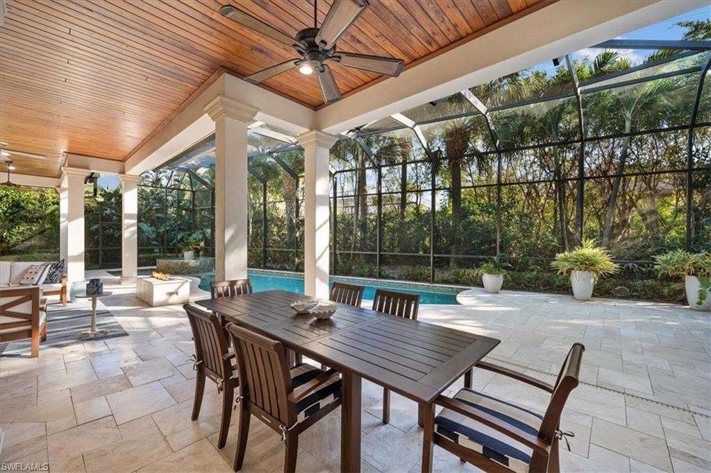 610 Springline Drive Naples, FL 34102 - Photo 11 of 49 a view of a patio with a dining table and chairs