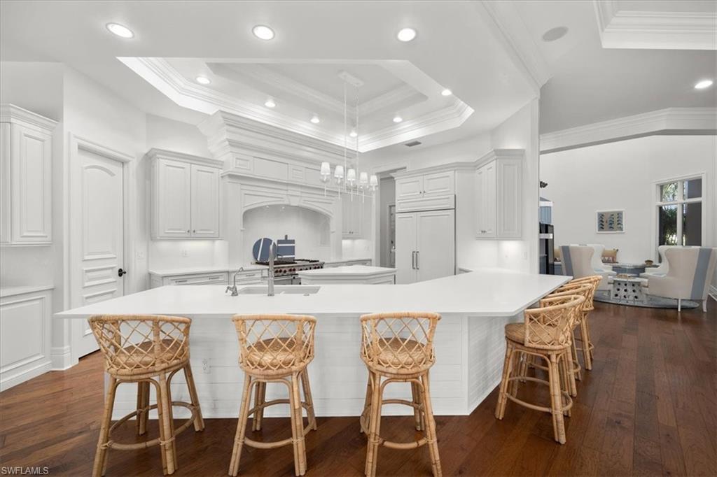 610 Springline Drive Naples, FL 34102 - Photo 15 of 49 a kitchen with stainless steel appliances kitchen island granite countertop a dining table chairs and white cabinets