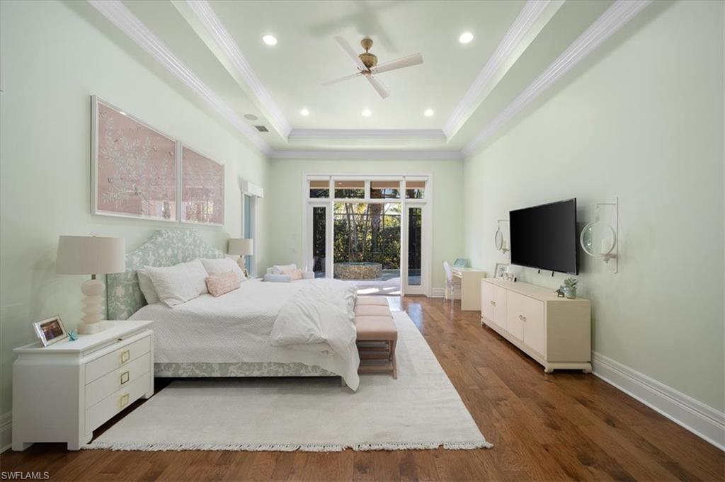 610 Springline Drive Naples, FL 34102 - Photo 30 of 49 a spacious bedroom with a bed and a flat screen tv