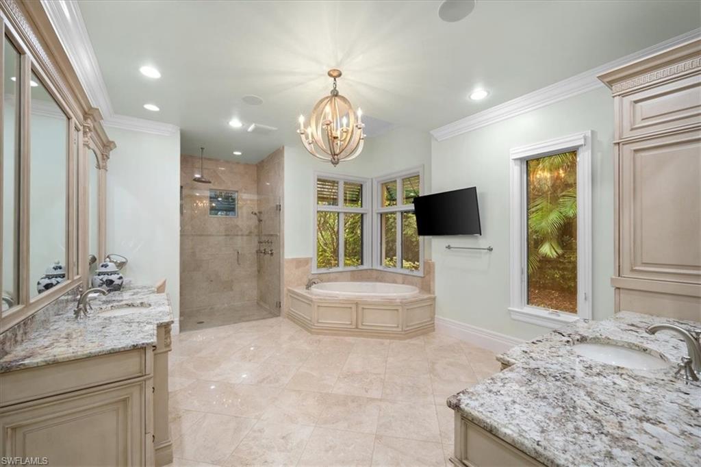 610 Springline Drive Naples, FL 34102 - Photo 34 of 49 a spacious bathroom with a granite countertop sink and a large mirror