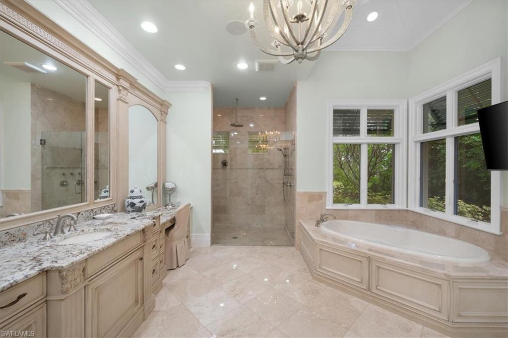 610 Springline Drive Naples, FL 34102 - Photo 35 of 49 a spacious bathroom with a granite countertop tub sink a mirror and a shower