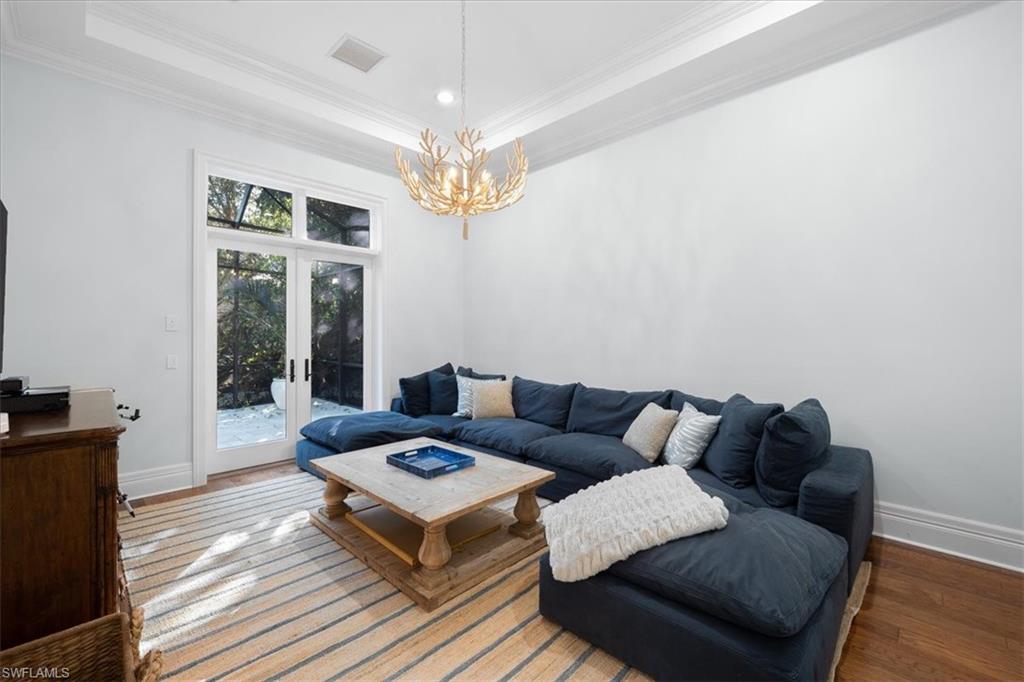 610 Springline Drive Naples, FL 34102 - Photo 44 of 49 a living room with furniture a chandelier and a window