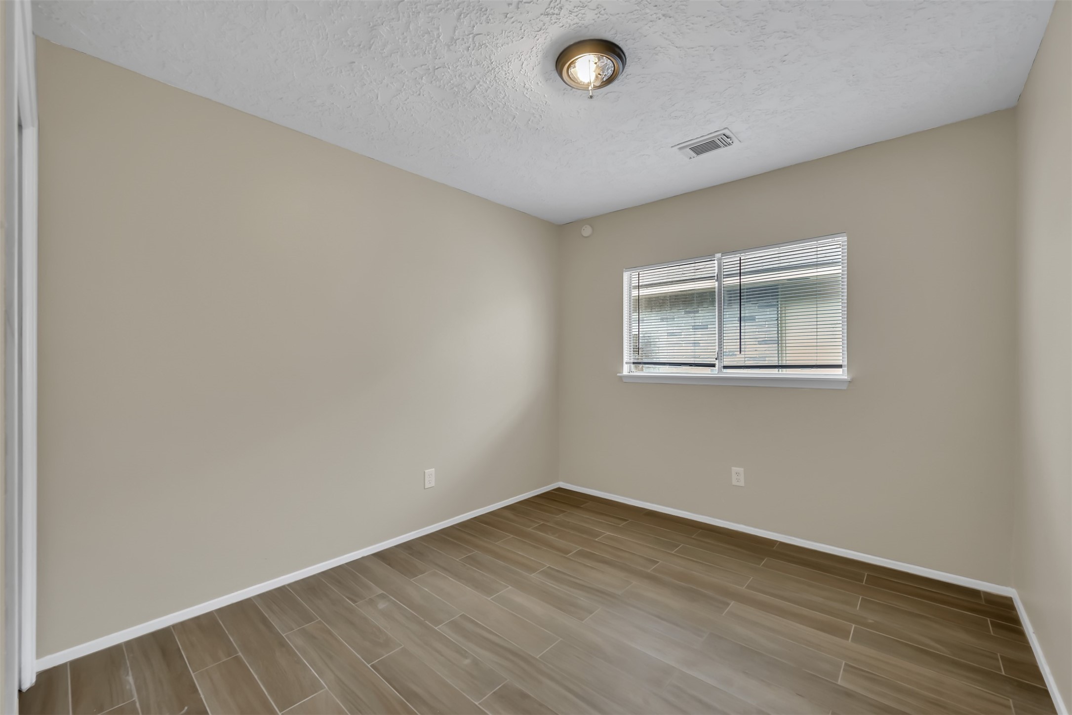 22112 Peachglen Lane Spring, TX 77373 - Photo 14 of 17 an empty room with wooden floor and windows