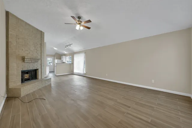 a view of a livingroom with a fireplace a chandelier and wooden floor