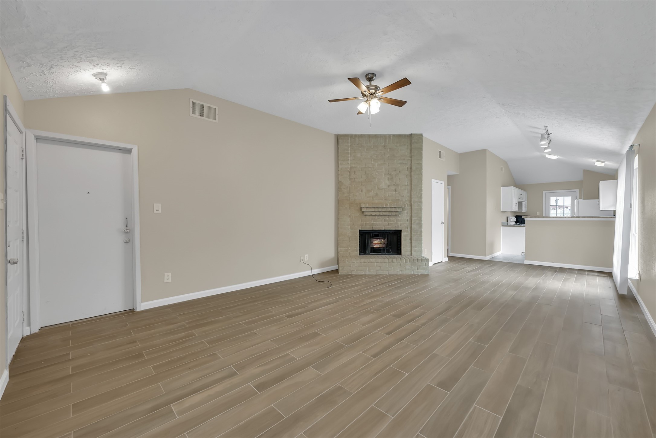 22112 Peachglen Lane Spring, TX 77373 - Photo 3 of 17 a view of an empty room with wooden floor and a kitchen